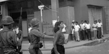 1965. Mujer es empujada por soldado norteamericano mientras caminaba por la calle. Foto Tomada del Caribe.